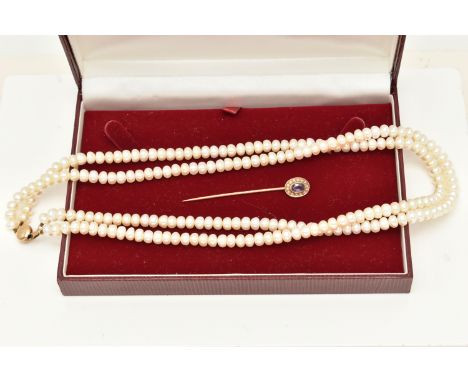 A YELLOW METAL AMETHYST AND SPLIT PEARL STICK PIN AND A CULTURED BAROQUE PEARL NECKLACE, the stick pin of an oval form set wi
