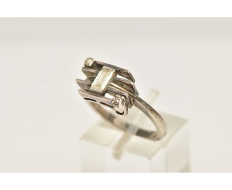 A WHITE METAL DIAMOND DRESS RING, set with a principal baguette cut diamond, measuring approximately 5.1 by 3.16mm (depth app