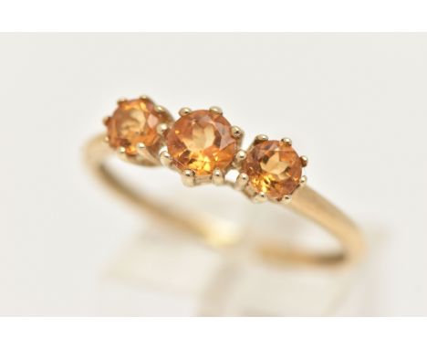A 9CT GOLD CITRINE RING, set with three circular cut citrines, each in a claw setting, leading onto a polished band, hallmark