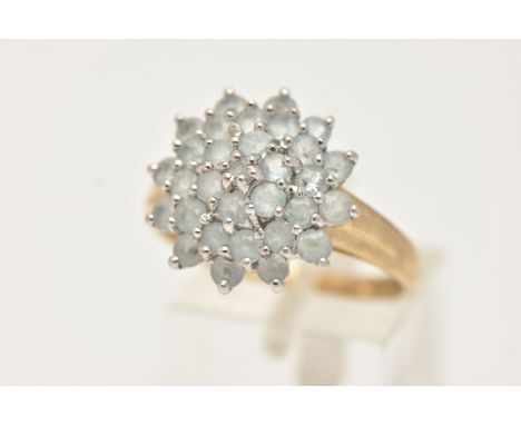 A 9CT GOLD CLUSTER RING, large circular cluster set with circular cut light blue stones, each claw set, to a polished band, h