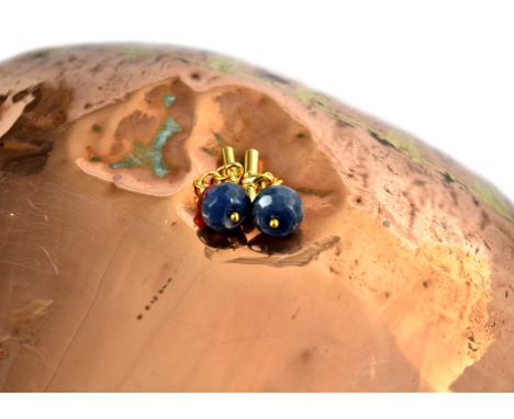 A pair of sapphire and ruby cufflinks, the terminal set with a large sapphire bead and a smaller ruby bead, 15 mm diameter, w