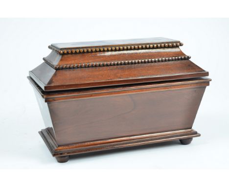 A 20th Century mahogany sarcophagus tea caddy, bead mouldings to lid, interior with two section lift-out tray above three sec
