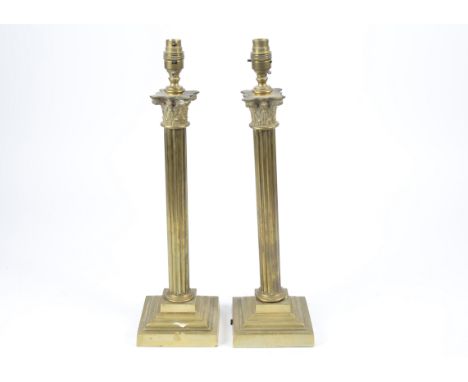A pair of late Victorian brass lamp bases, shaped as Corinthian columns on stepped square bases, 50 cm high (2)
