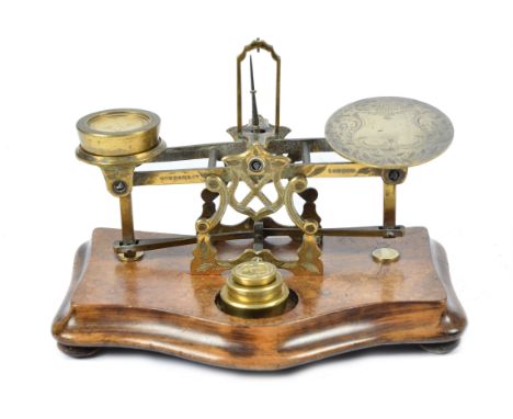 A set of brass postal scales by Sampson Mordan &amp; Co. London, on a walnut base, with four weights, 15 cm high