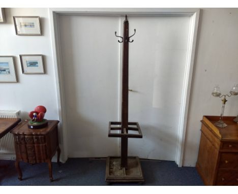 An oak hall stand, tapering column with finial, four hooks, four section umbrella stand with drip tray, square base, bun feet