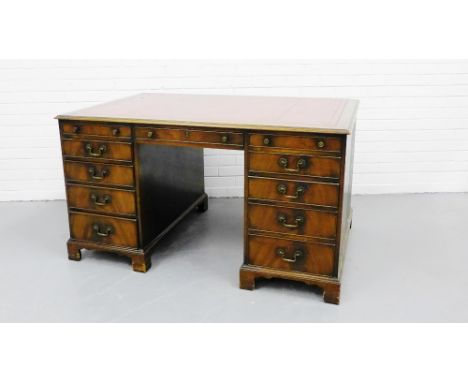 Mahogany Partner's desk, the rectangular top with red tooled leather skiver, over central drawer flanked by five drawers to e