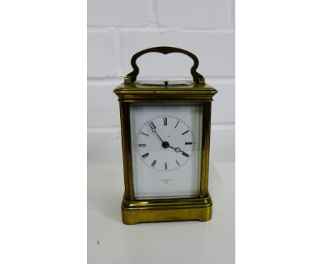 Brass cased carriage clock, the white enamel dial with Roman numerals and marked T.R Russell, Paris, with brass loop handle t