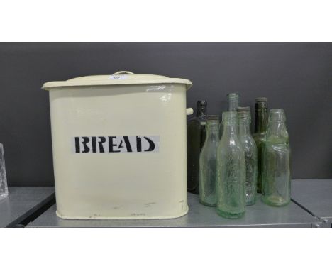A vintage enamel bread bin together with a collection of late 19th early 20th century glass bottles.