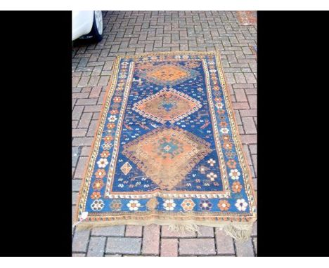 An antique Middle Eastern carpet with navy blue ground and geometric border - 205cm x 110cm 