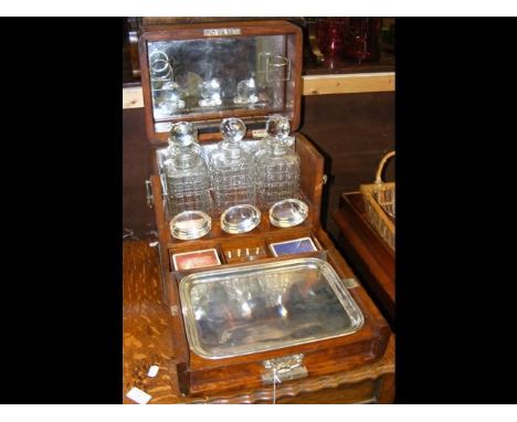 An antique three bottle tantalus and games compendium cabinet, with silver plated trays marked W M FCONDITION REPORTcan not s