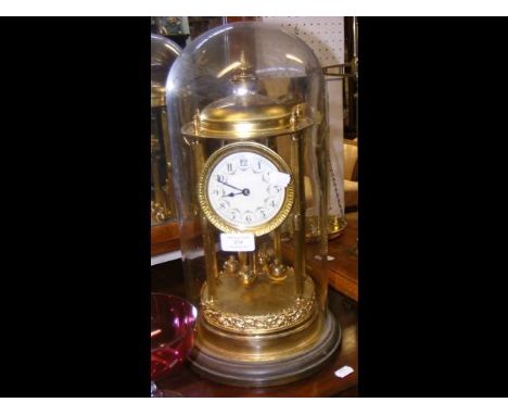 A decorative gilt mantel clock under glass dome - 44cm high 