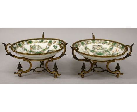 A PAIR OF LATE 19TH CENTURY CHINESE FAMILLE VERTE PORCELAIN DISHES, in the form of a pair of saucers supported by European gi