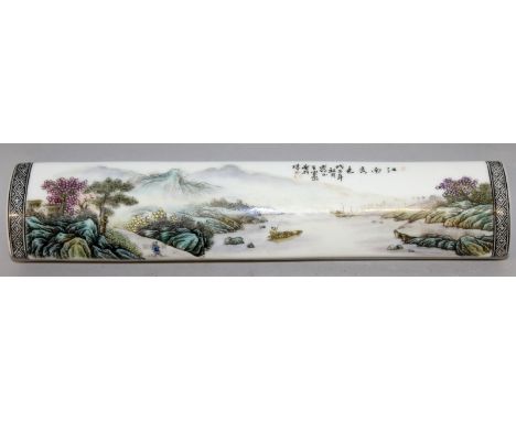 A CHINESE FAMILLE ROSE PORCELAIN SCROLL WEIGHT, decorated with calligraphy and a river landscape scene, the base unglazed, 10