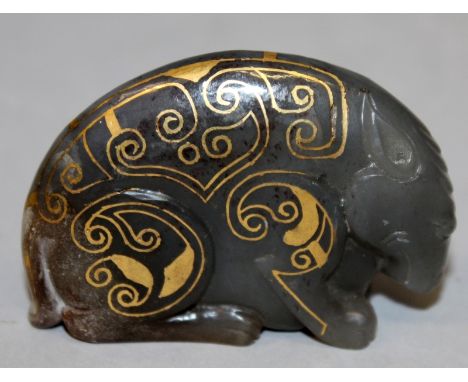 A CHINESE GILT-METAL INLAID JADE MODEL OF A MYTHICAL ANIMAL, rendered in an archaic style, 2.7in long & 1.8in high.