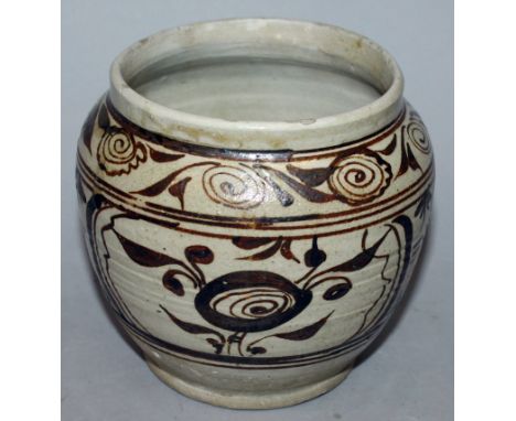 A CHINESE YUAN DYNASTY CIZHOU CERAMIC JAR, decorated in brown on a white slip ground with panels of flowerheads, the glaze fa