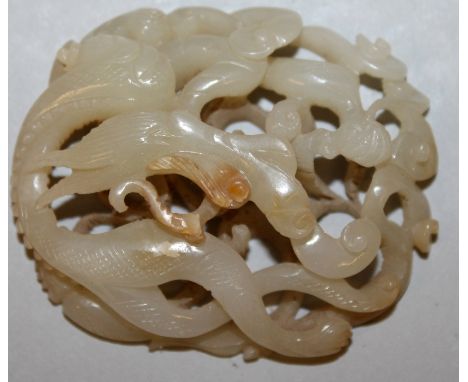 A GOOD QUALITY CHINESE JADE OVAL PLAQUE, pierced in high relief with a sinuous dragon, 2in wide x 1.7in.