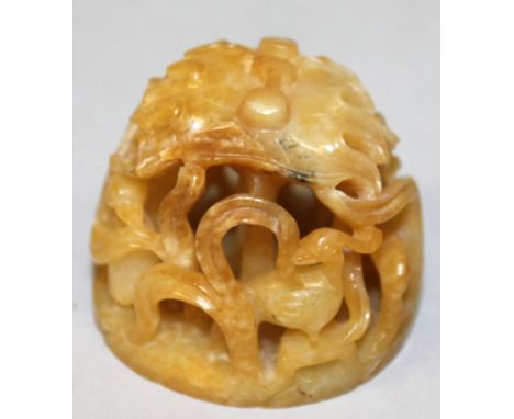 AN UNUSUAL CHINESE YELLOW JADE HAT BUTTON, with pierced decoration of birds and lotus, 1.9in diameter at base & 1.7in high.