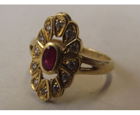 Yellow metal dress ring with central ruby, surrounded by white "sapphire?"