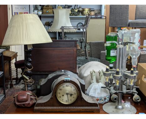 A mixed lot to include a plated drinks dispenser stand, two mantel clocks, a barley twist table lamp, brushed chrome taps, Vo