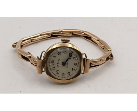 An early 20th century 9ct gold ladies manual wind wrist watch on a yellow metal expanding bracelet, 12.4 gramsLocation: 