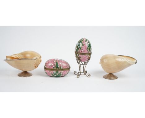 A pair of porcelain eggs formed as trinket boxes, each gilt foliate decorated against a pink ground with gilt metal mounts, o