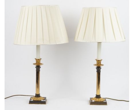 A pair of gilt and patinated metal lamps, modern, of fluted candlestick form, on a foliate cast square base, 35cm high, (2). 