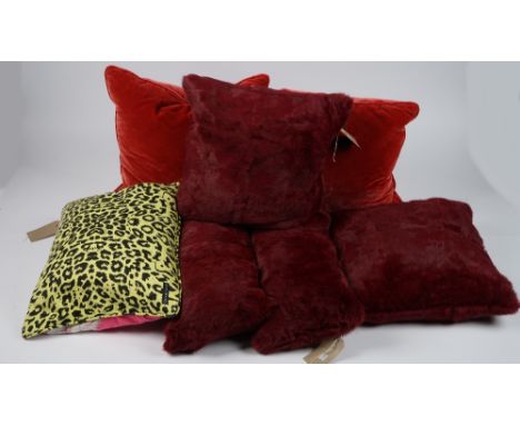 Four faux fur maroon cushions, two red velvet and one bright pink and leopard print cushion, (6). 