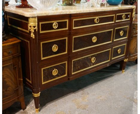 A Louis XVI style mahogany and ormolu mounted marble topped commode on fluted tapering supports, 138cm x 85cm high. 