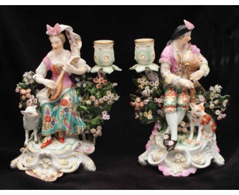 A PAIR OF DERBY FIGURAL PORCELAIN CANDLESTICKS one in the form of a lady playing a lute with sheep alongside, the other her m