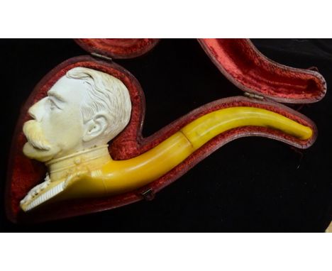 An early 20th century meerschaum pipe, the bowl in the form of Lord Kitchener's head, in its red velvet lined leather covered