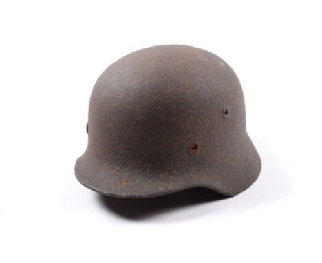 The skull of a WWII German M40 steel helmet, heavily corroded, probably a battlefield relic; also an Intelligence Corps offic