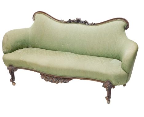 A Victorian mahogany sofa, the part show frame decorated with scrolls, leaves and flowers, upholstered in green fabric, on ca