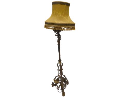 A late 19thC gilt metal floor lamp, decorated in French style with swags, leaves, etc., the triform base supported by scrolls