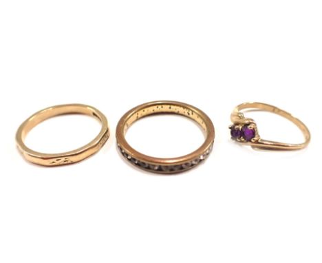 Three dress rings, comprising a 9ct gold wedding band, of hammered design, ring size K½, a 9ct gold and amethyst set twist ri