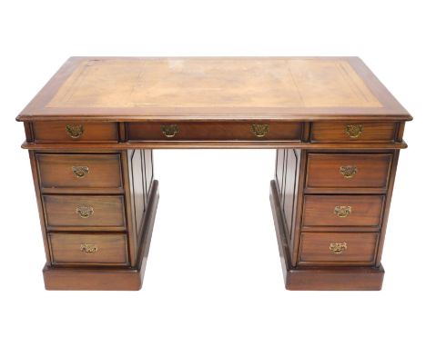 A mahogany pedestal desk, the rectangular top with a brown gilt tooled leather inset above an arrangement of nine drawers, on