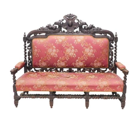 A late 19th/early 20thC ebonised oak sofa, in Carolean style, the high back decorated with scrolls, leaves and spirally turne