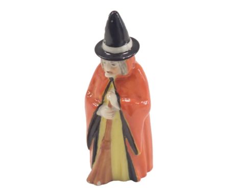 A Royal Worcester candle snuffer, modelled as a witch in red overcoat, 10cm high. 