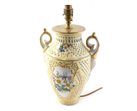 A Continental porcelain lamp base, with pierced decoration surrounding floral sprays within gilt borders, 39cm high overall. 