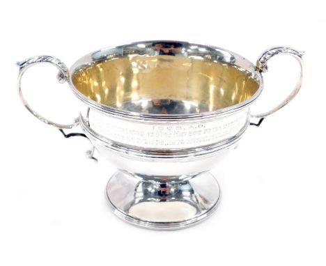 A late Victorian two-handled silver sugar basin, of urn shaped design with leaf capped query handles and reeded borders, with