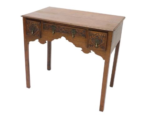 An early 19thC oak lowboy, the rectangular top with a moulded edge above three later carved drawers, around an apron, on cham