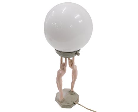 An Art Deco painted metal lamp base, modelled in the form of two nudes holding the opaque glass fitting, the lamp 31cm high. 
