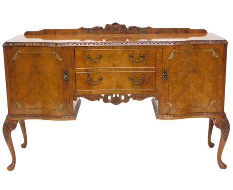A figured and burr walnut sideboard, with a raised back, a serpentine shaped front with carved frieze, above two drawers and 