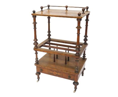 A Victorian figured walnut and marquetry Canterbury whatnot, the top with turned finials and brass three quarter gallery, on 
