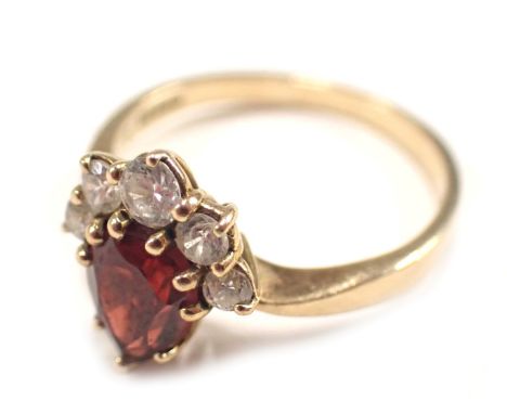 A 9ct gold dress ring, set with garnet and cz stones, the garnet of teardrop cut design, with three graduated czs, ring size 