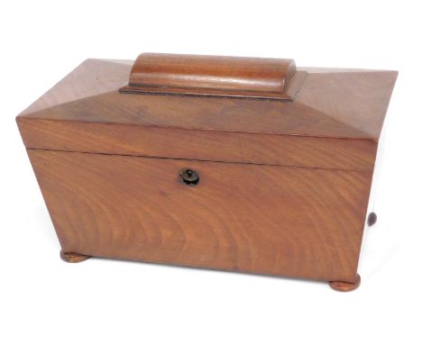 A Victorian mahogany sarcophagus shaped tea caddy, the hinged lid enclosing a part fitted interior, on bun feet, 27.5cm wide.