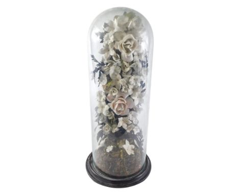 A 19thC Victorian style ceramic and composition flower arrangement or display, on a naturalistic base in tall glass dome, wit