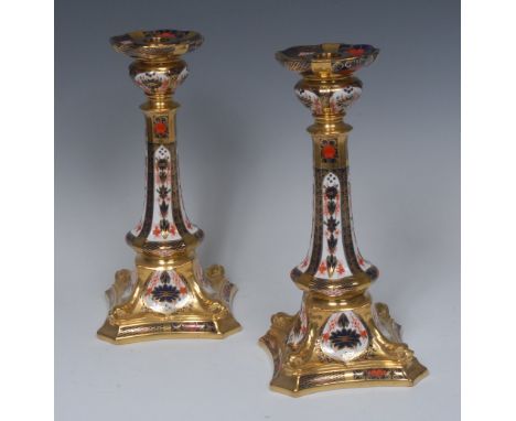 A pair of Royal Crown Derby 1128 pattern Castleton candlesticks, dolphins to angles, incurved square bases, 27cm high, printe