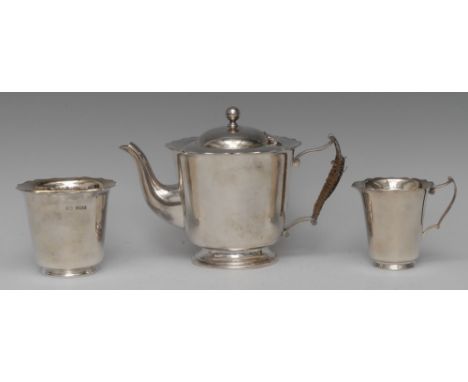 An Edwardian silver three piece tea service, comprising teapot, milk jug and sugar basin, wavy borders, scroll handles, the t