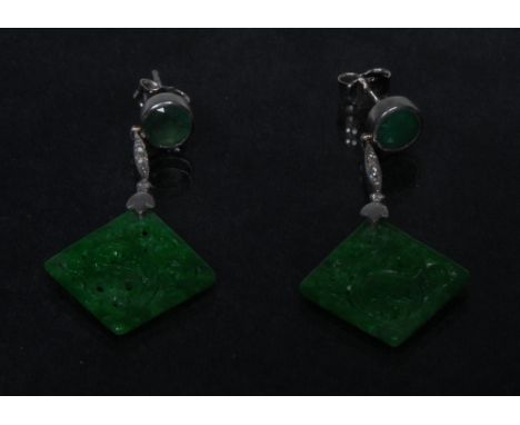 A pair of emeralds and diamond earrings, each with a floral carved and pierced diamond shaped emerald panel, four stone diamo