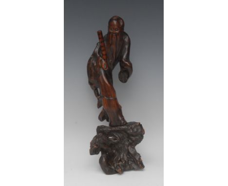 A Chinese rootwood carving, of a scholar, he stands, holding a scroll, 41cm high
